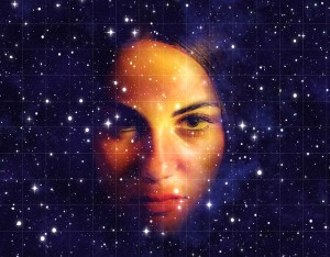 Close up of a woman's face, deep in thought, sober, superimposed over a night sky full of stars, so that some of the stars are visible on her face.